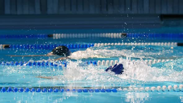 Man and woman swimming together inside the pool 4k