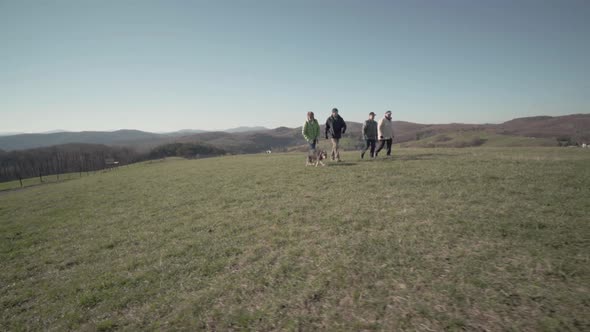 Seniors Taking Dog for a Walk on Meadow