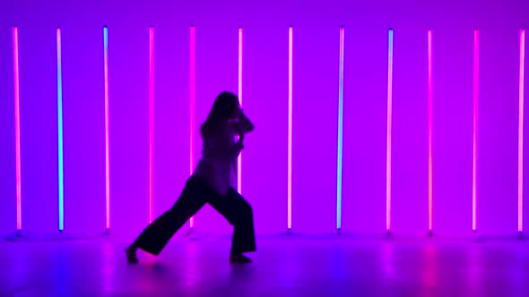 Woman Dancer Dancing Contemporary in the Studio Against the Background of Multicolored Neon Tubes