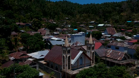 Aerial drone view of a small isolated village and situated at the bottom of a mountain close to the