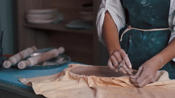 Potter Forming Clay Into a Dish By Using a Form and Tools To Get the Perfect Shape