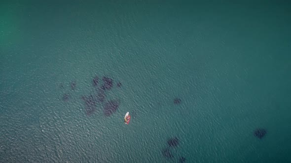 Aerial view of windsurfer and boat in turquoise sea in Greece