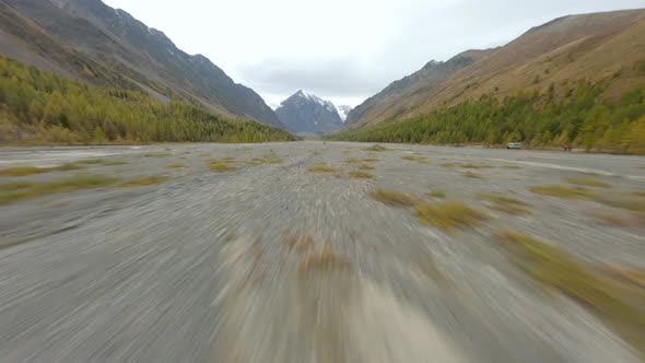 FPV Sport Drone Flying Over Wild River Valley Fast Running Man Surrounded By Natural Mountain Ridge