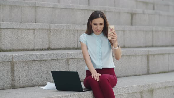 Businesswoman Having Video Chat on Smartphone. Manager Using Phone Outdoors