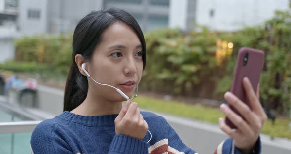 Woman having voice message on cellphone at city