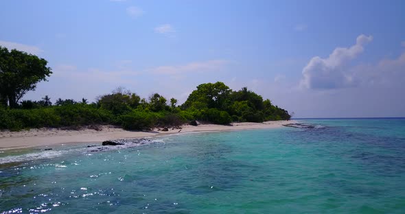 Tropical birds eye travel shot of a white sand paradise beach and aqua blue ocean background in vibr