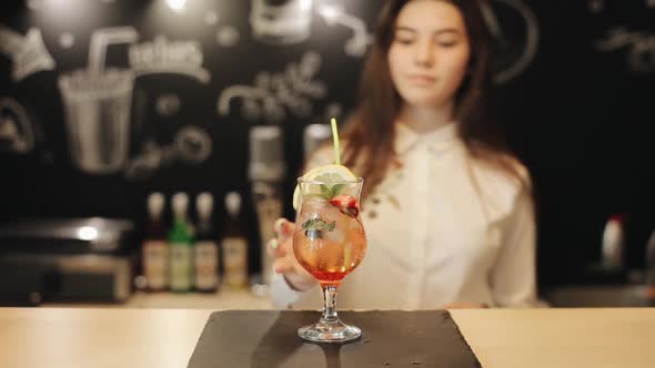 A Beautiful Young Female Barista Tasting a Strawberry Mojito