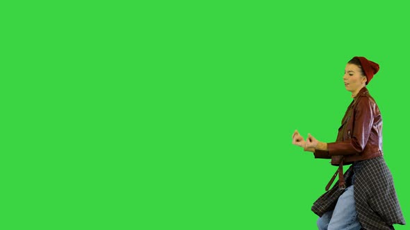 Young Girl in Stylish Urban Clothes Walks Dancing on a Green Screen Chroma Key
