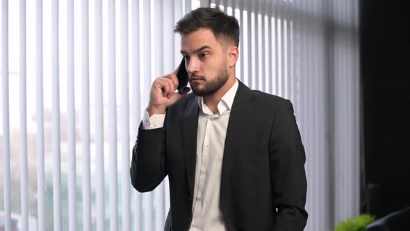 A young male manager or supervisor listens carefully, then yells into the phone