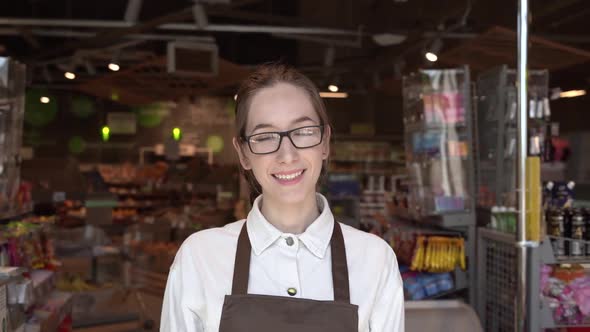 The Girl Supermarket Cashier Smiles for the Camera