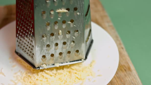 Slow motion of A cook grater Parmesan cheese, typical Italian cheese, on the plate just freshly brew