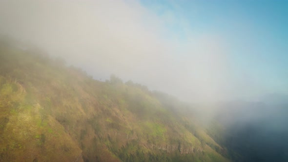 Aerial view of Mount Bromo located in East Java, flying through the clouds with dramatic backlight