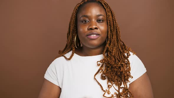 Studio Portrait of Cute African American Lady Sending Blow Kiss to Camera Brown Background