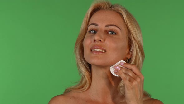 Attractive Mature Woman Wiping Her Face with a Cotton Pad
