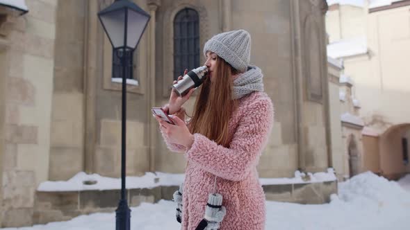 Traveler Woman Holding Mobile Phone Chatting with Friends and Family Drinking Hot Drink Tea