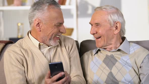 Happy Retired Men Laughing Watching Smartphone Photos, Fast Internet Connection