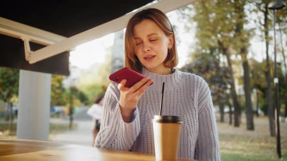 Young girl using smartphone voice recognition, voice dialing message student in the cafe, audio ai.