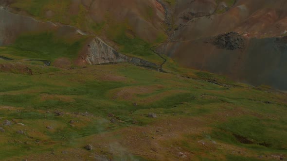 iceland landscape, geothermal hotspring steam smoke valley, camera tilt up , telephoto lens