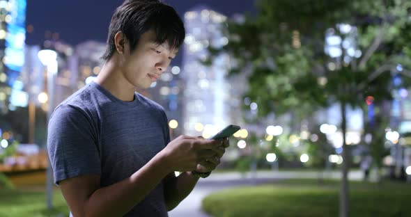 Man use of mobile phone in the city at night 