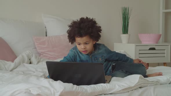 Multiethnic Boy Watching Video Online Using Laptop