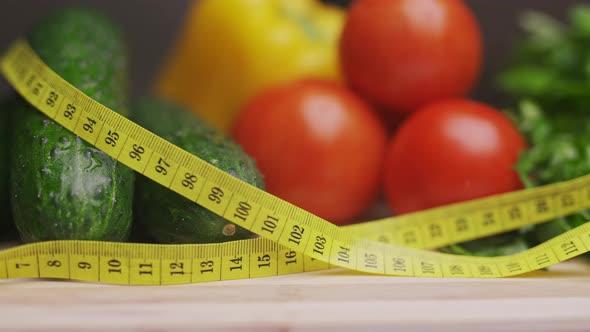 A Side View of Yellow Measuring Tape and Fresh Vegetables on a Wooden Cutting Board