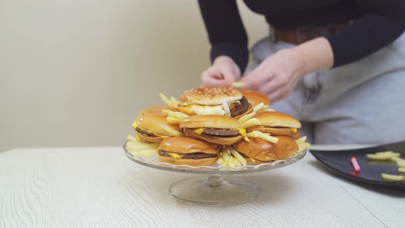 Woman Place Cheeseburgers and French Fries on a Round Glass Dish