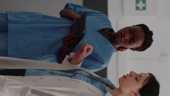 Vertical Video African American Physician Nurse Checking Disease Expertise on Tablet