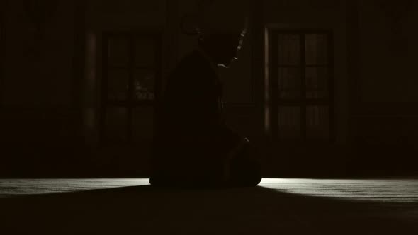 Silhouette of people praying in mosque.