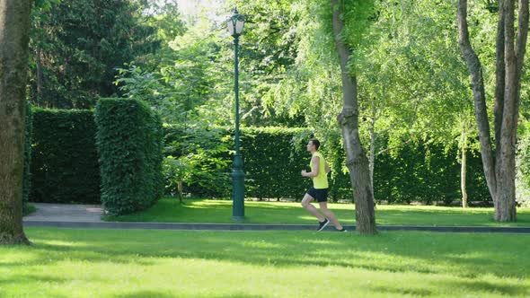 Man Jogging Against Garden Maze in Slow Motion