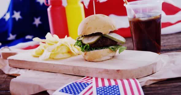 Hamburger and cold drink on wooden board