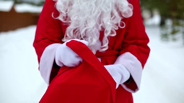 Food delivery service containers in hands of Santa Claus outdoor in snow. Christmas eve promotion. R