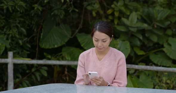 Woman use of mobile phone at outdoor cafe