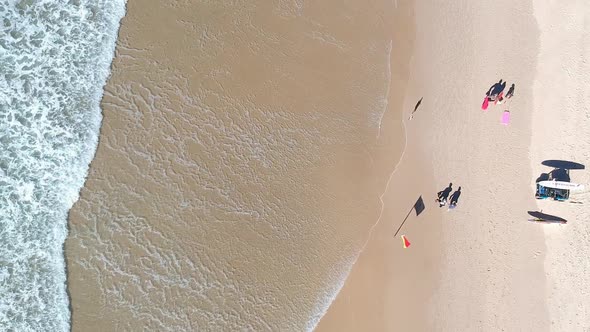 Aerial view of an Australian beach with lifesaving equipment near people walking