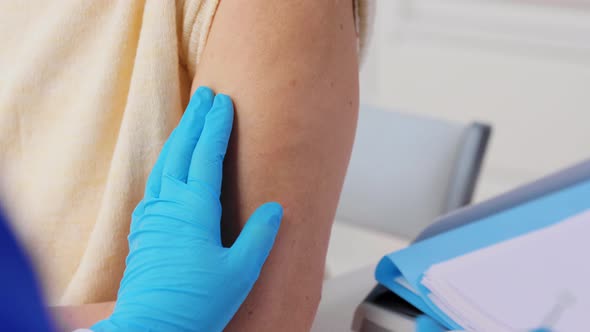 Nurse with Syringe Making Injection to Woman