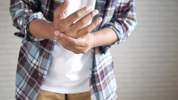 Man in Casual Dress Suffering Pain in Hand Close Up