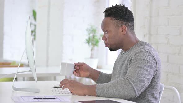 Disappointed Casual African Man Working on Desktop in Office 