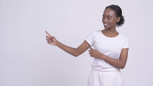 Happy Young Beautiful African Woman Pointing and Showing Something