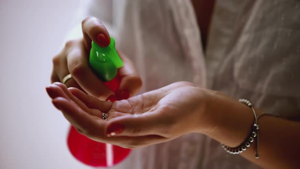 A woman squeezes liquid from a vial onto her hand