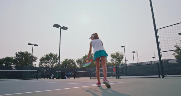 Female Tennis Player Hitting Small Ball Using a Racket