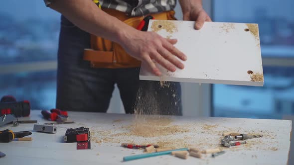 Man Shaking Off Shavings From Board