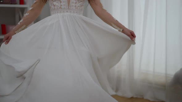 Happy Cheerful Middle Eastern Bride Spinning in Elegant White Wedding Dress Laughing