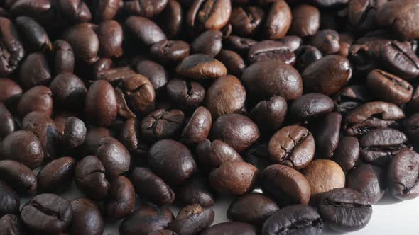 Pile of roasted coffee beans close-up 4K slow tilt footage