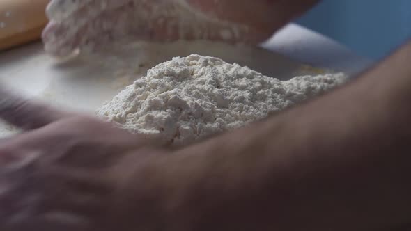 Closeup Shot of Male Hands Ff Baker Kneading Dough in Flour on Wooden Table at Home