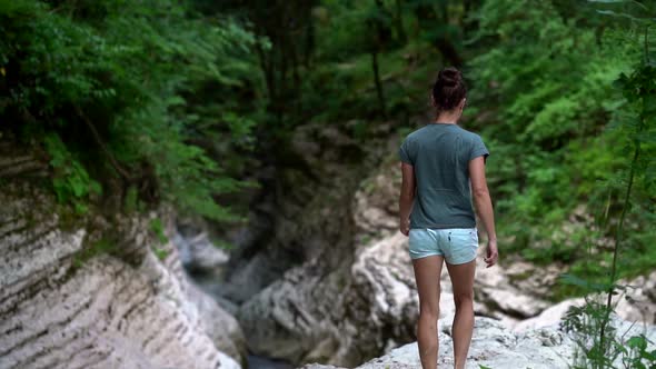 Female Traveler Is Walking in Beautiful Nature and Rejoicing, Lifting Hands Up and Jumping