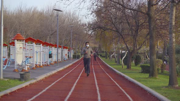 4K covid 19 masked man running in park