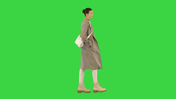 Young Woman in Smart Casual Clothes Walks Slowly on a Green Screen Chroma Key