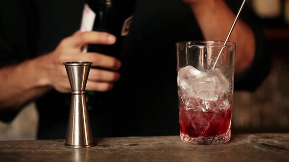 Bartender adding vermouth to cocktail