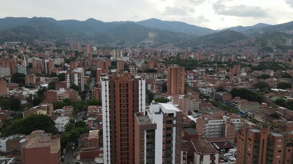 Flying low above large apartment building in a large city, Medellin, Colombia