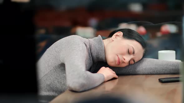 Upset Young Asian Woman Feeling Pain Crying Lying on Table at Public Cafeteria