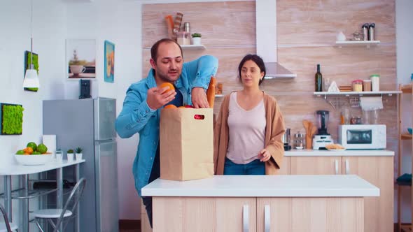 Guy Juggle for Wife in Kitchen